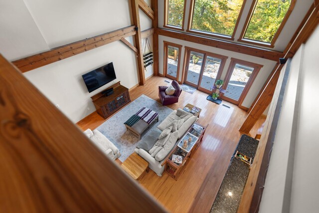 living area featuring light wood-type flooring and a towering ceiling