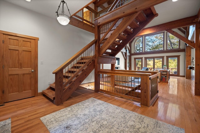 interior space featuring baseboards, high vaulted ceiling, and wood finished floors