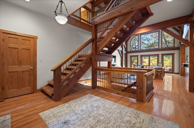 270 Wondering Woods Dr, Somerset, KY 42503 - unfurnished living room featuring hardwood / wood-style flooring, high vaulted ceiling, recessed lighting, stairway, and baseboards
