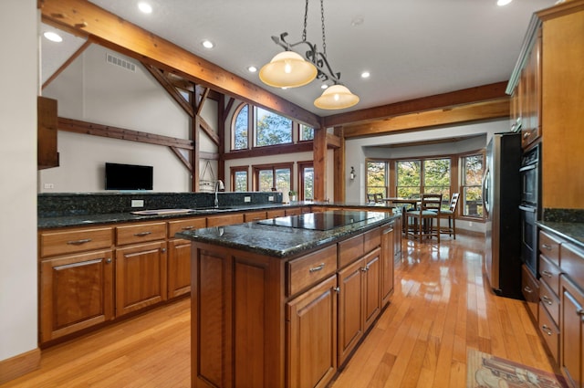 kitchen with stainless steel appliances, pendant lighting, brown cabinetry, and a kitchen island