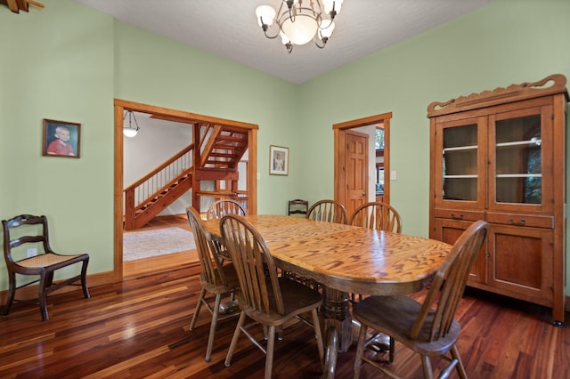 dining room featuring stairs, dark wood-style flooring, baseboards, and an inviting chandelier