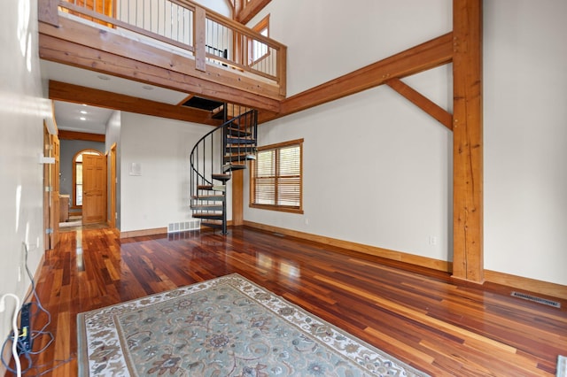 270 Wondering Woods Dr, Somerset, KY 42503 - unfurnished living room featuring wood finished floors, stairway, baseboards, arched walkways, and a high ceiling