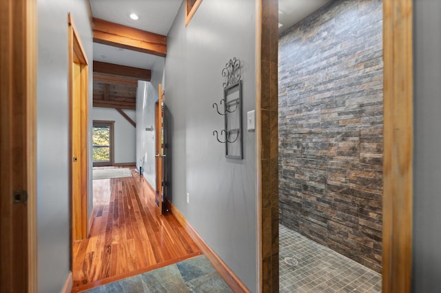 hall with wood finished floors, beam ceiling, and baseboards