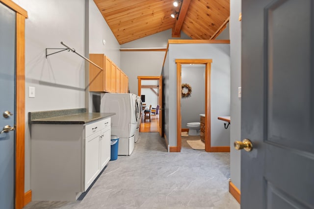 kitchen with lofted ceiling with beams, wooden ceiling, white cabinets, washer and dryer, and dark countertops