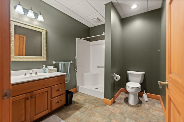 bathroom featuring visible vents, a stall shower, vanity, a drop ceiling, and baseboards