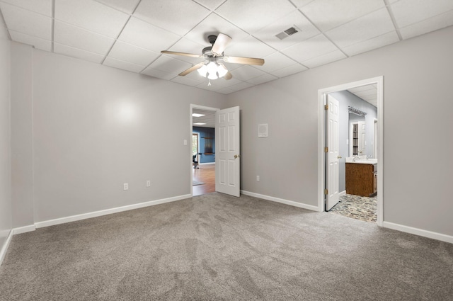 unfurnished bedroom with carpet floors, a drop ceiling, and baseboards