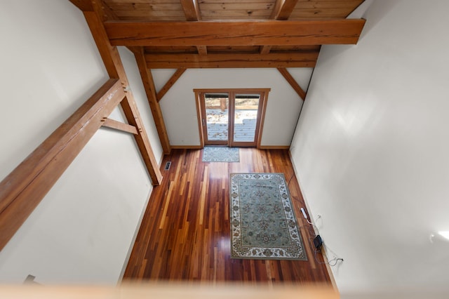 interior space featuring vaulted ceiling with beams, wooden ceiling, and dark wood finished floors