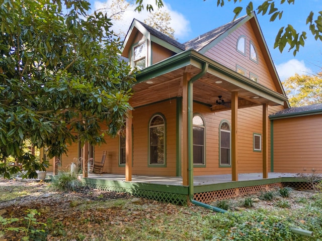 view of side of property with a ceiling fan and a wooden deck