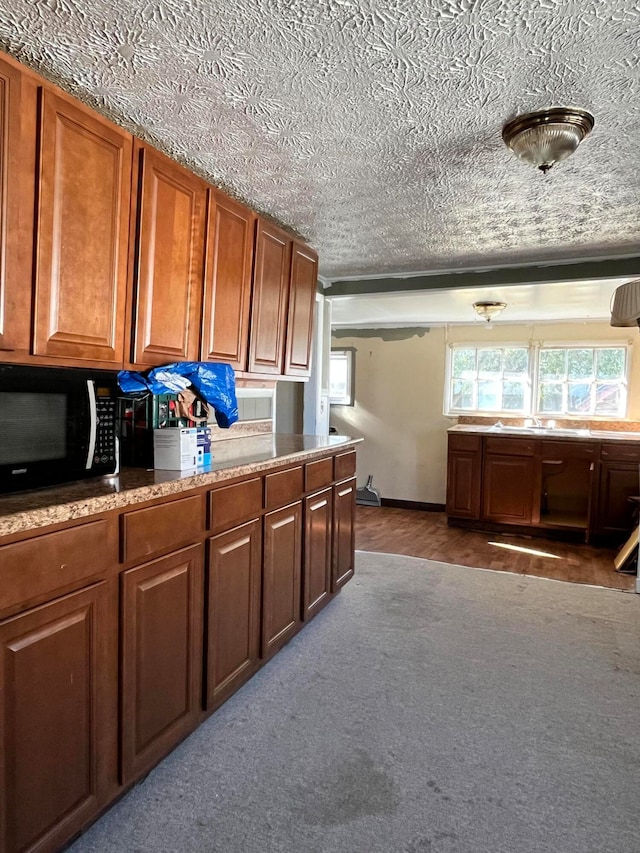 kitchen with a textured ceiling and dark colored carpet