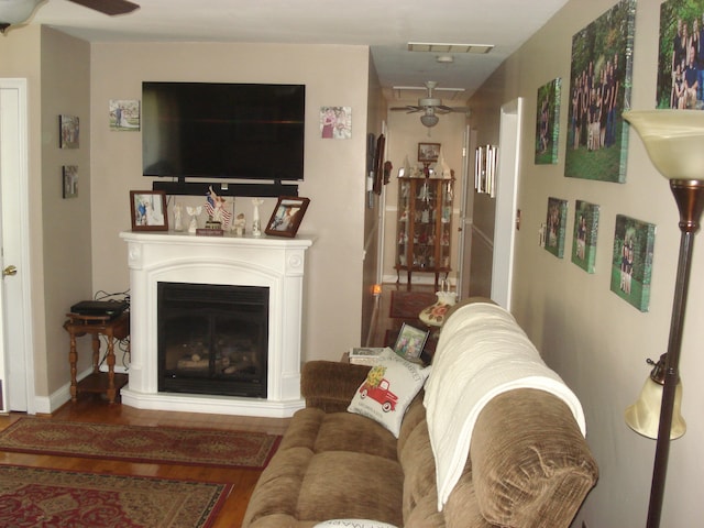 living room featuring wood-type flooring and ceiling fan