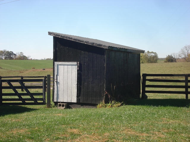 view of outdoor structure with a rural view and a yard