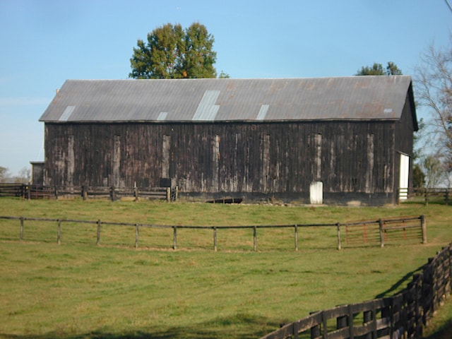 view of outbuilding with a lawn and a rural view