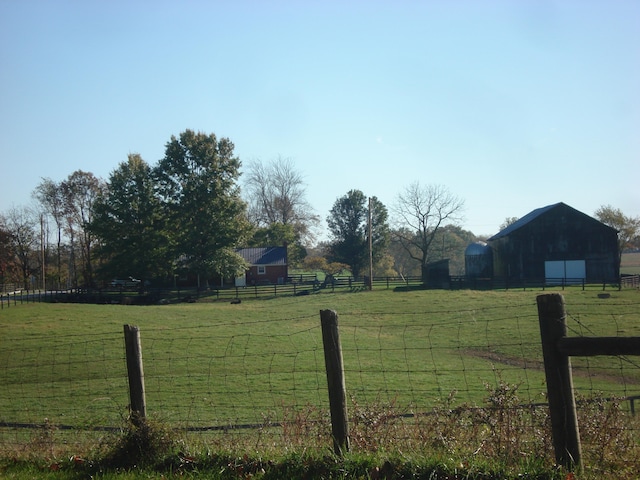 view of yard with an outbuilding and a rural view