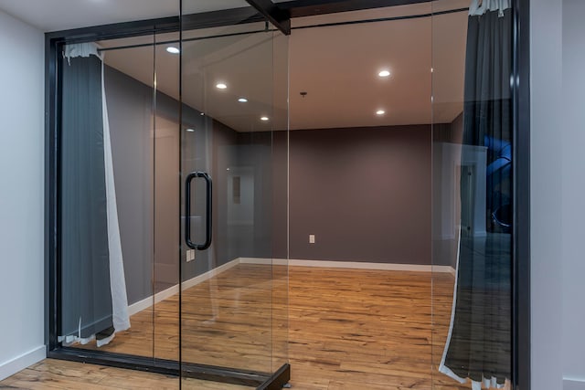 bathroom featuring hardwood / wood-style floors and a shower with shower door