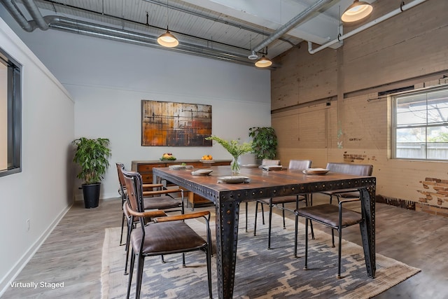 dining area with hardwood / wood-style floors and a high ceiling