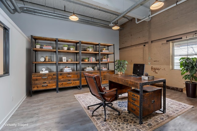 office with a high ceiling and hardwood / wood-style flooring