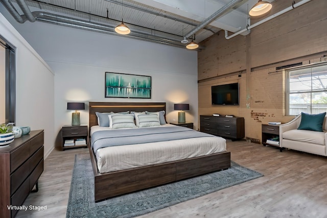 bedroom featuring a high ceiling and hardwood / wood-style floors