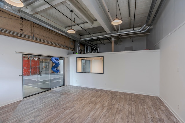 spare room featuring a towering ceiling and hardwood / wood-style flooring