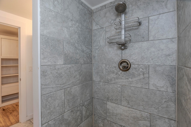 bathroom featuring tiled shower and wood-type flooring