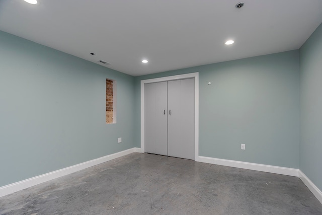 unfurnished bedroom featuring a closet and concrete floors