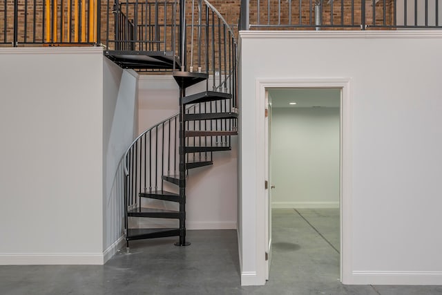 stairway with a high ceiling and concrete floors