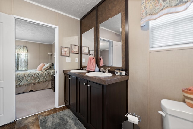 bathroom featuring toilet, crown molding, a textured ceiling, and vanity