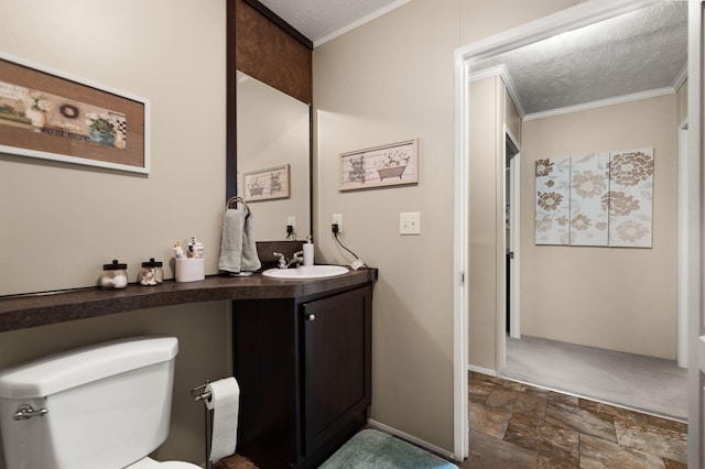 bathroom with vanity, ornamental molding, a textured ceiling, and toilet