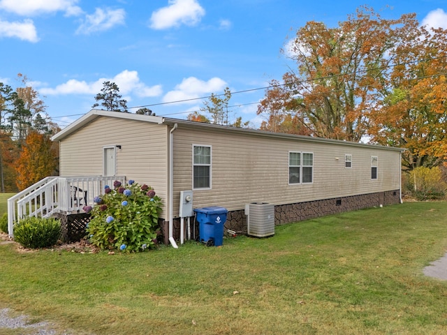 exterior space with a wooden deck, a yard, and central AC unit