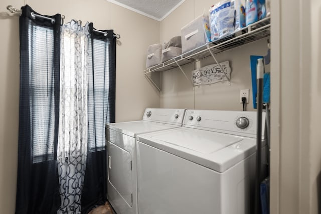 laundry area featuring ornamental molding, independent washer and dryer, and a textured ceiling