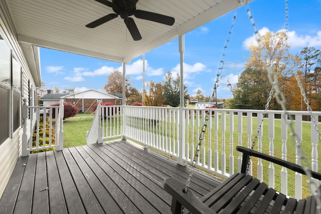 wooden deck featuring ceiling fan and a lawn