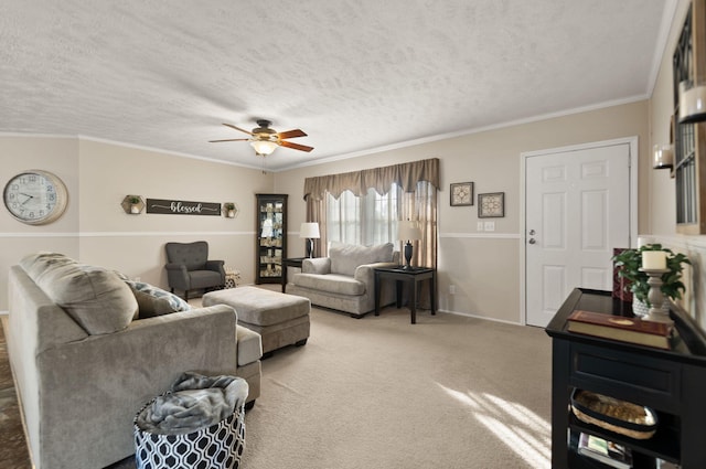 carpeted living room featuring ceiling fan, crown molding, and a textured ceiling