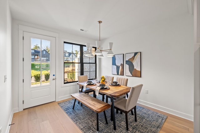 dining area with a chandelier and light hardwood / wood-style floors