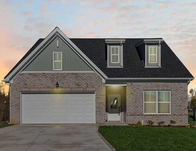 view of front of property with driveway, a shingled roof, an attached garage, a front yard, and brick siding