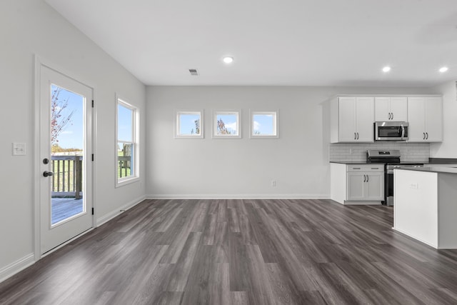 148 Nuthatch Trl, Georgetown, KY 40324 - kitchen with appliances with stainless steel finishes, dark countertops, dark wood finished floors, white cabinets, and backsplash