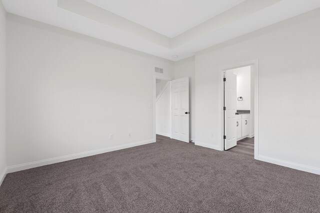 148 Nuthatch Trl, Georgetown, KY 40324 - unfurnished bedroom featuring dark carpet, baseboards, a tray ceiling, and ensuite bath