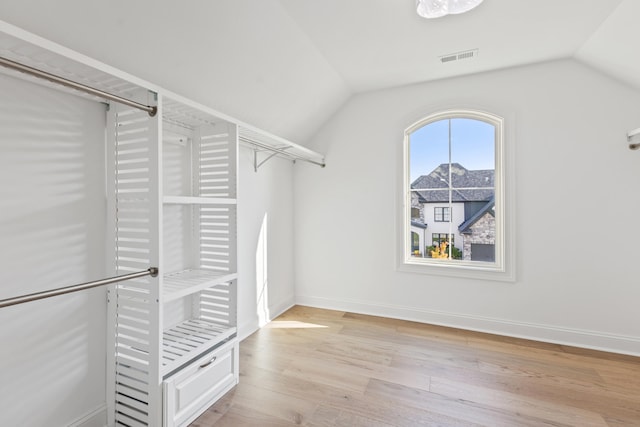 spacious closet featuring light hardwood / wood-style flooring and vaulted ceiling