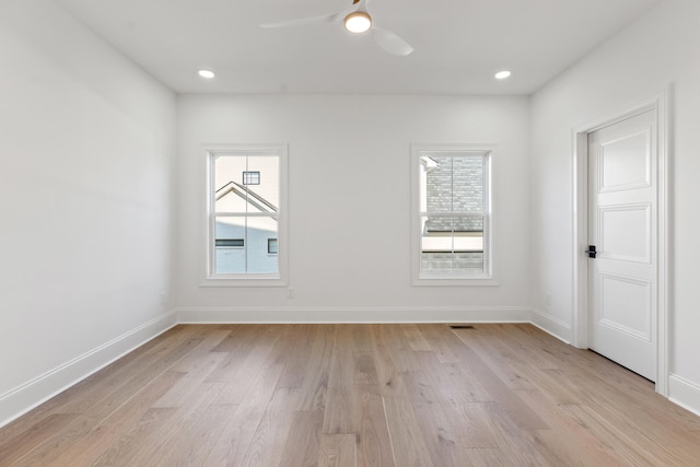 spare room with ceiling fan, light wood-type flooring, and a wealth of natural light