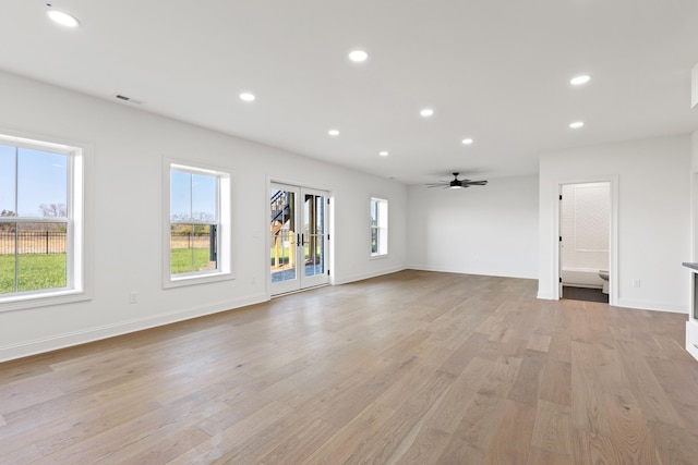 empty room with french doors, light hardwood / wood-style floors, and ceiling fan