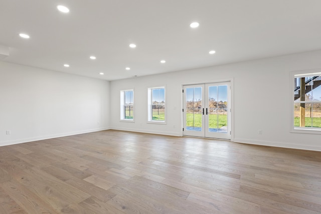 spare room with french doors and light hardwood / wood-style floors