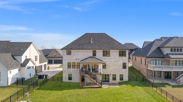 back of house featuring a garage, a balcony, a yard, and a patio area