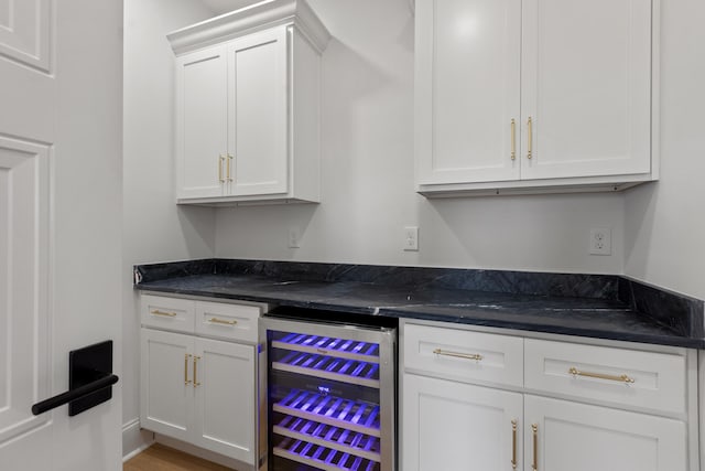 bar featuring hardwood / wood-style floors, white cabinets, and beverage cooler