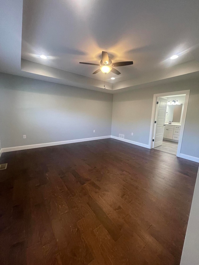 spare room featuring dark wood-type flooring and ceiling fan