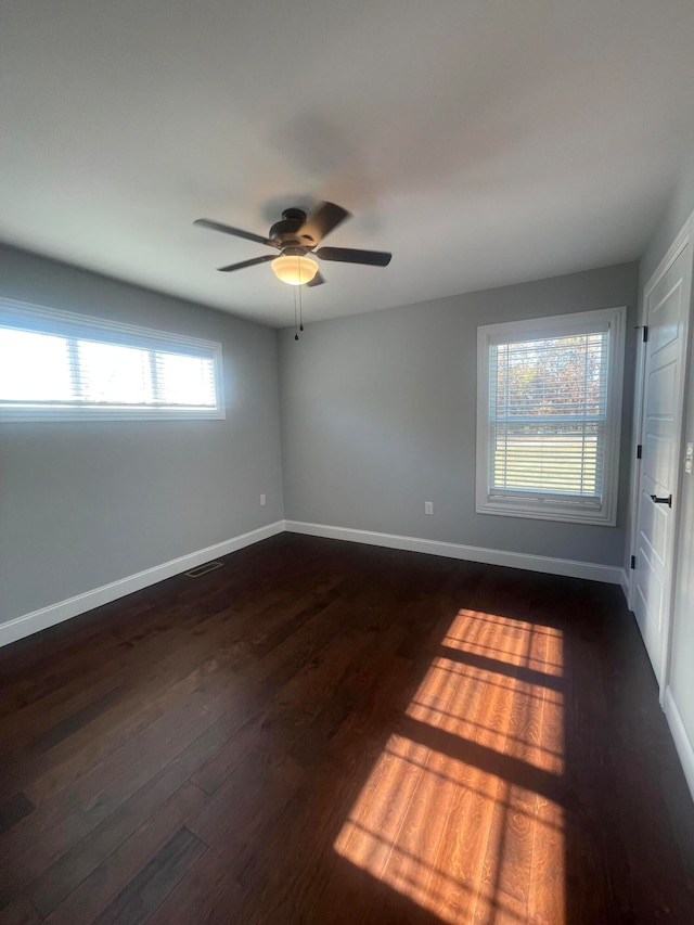 spare room with dark wood-type flooring and ceiling fan