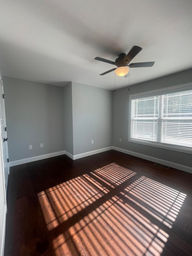 unfurnished room featuring ceiling fan and dark hardwood / wood-style flooring