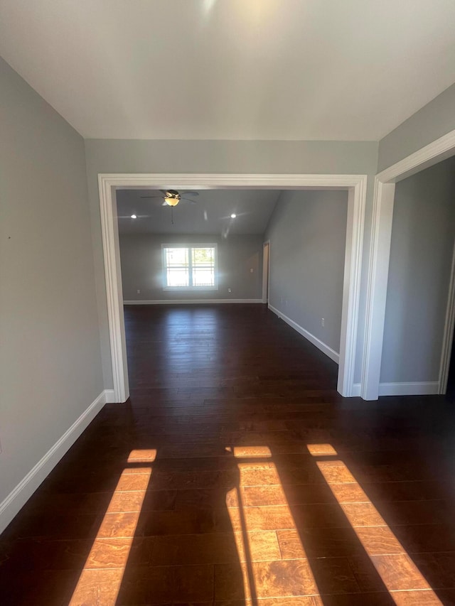 unfurnished living room with dark wood-type flooring and ceiling fan