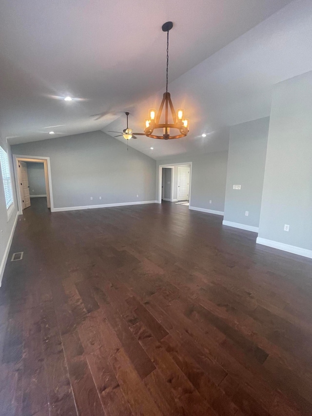 spare room featuring dark hardwood / wood-style floors, ceiling fan with notable chandelier, and vaulted ceiling