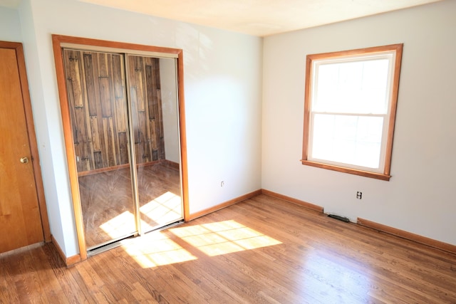 unfurnished bedroom featuring a closet and hardwood / wood-style flooring