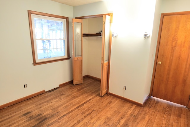 unfurnished bedroom with light wood-type flooring and a closet