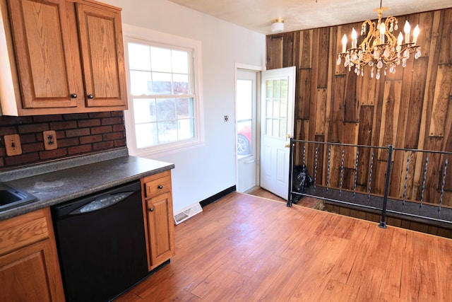 kitchen featuring tasteful backsplash, dishwasher, a notable chandelier, hardwood / wood-style floors, and pendant lighting