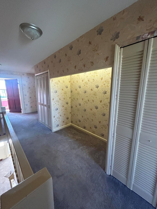 hallway with carpet flooring and vaulted ceiling